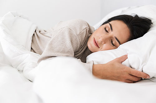Image Text: 500x332_0008_Photo of middle-aged woman 30s sleeping, while lying in bed with white linen at home